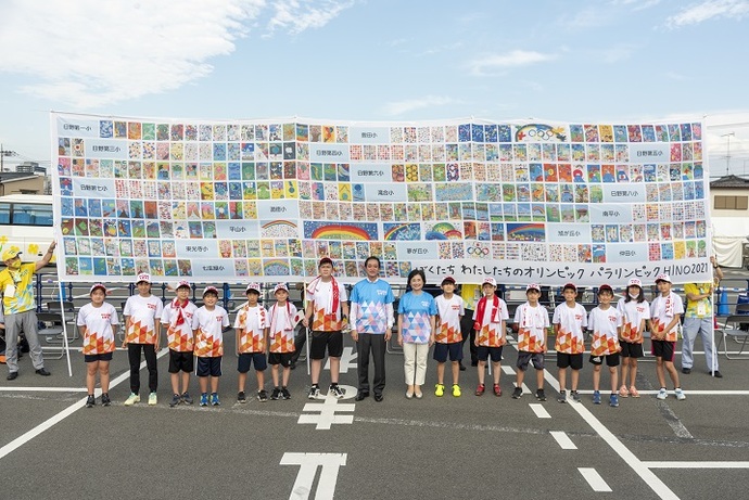 全小学校絵画作品の横断幕をバックに小学生サポートランナーの集合写真