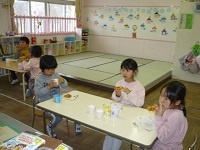 5歳児らいおん組が出来上がったピザを食べている写真