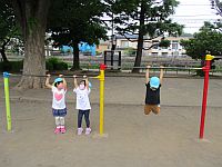 鉄棒で遊ぶ4歳児クラスの子どもたちの写真