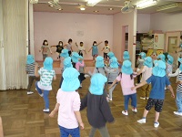 4歳児ぞう組が5歳児らいおん組に盆踊りを教わっている写真
