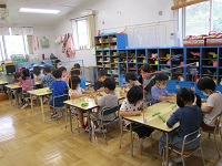 5歳児がそら豆のさやを剥いている写真です。