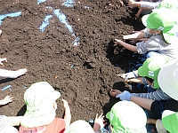 土をまぜている子どもたちの写真