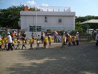 園庭に避難した幼児クラスがホールに移動している写真