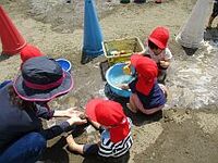 1歳児の子どもたちが泥んこで遊んでいる写真