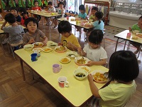 みんなでカレーライスの食事をしている写真