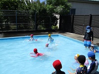 5歳児らいおん組が第八小学校のプールで遊んでいる写真