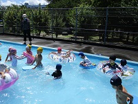 5歳児らいおん組が第八小学校のプールで浮き輪を使って遊んでいる写真写真