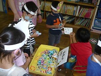 5歳児らいおん組が景品のブレスレットを渡している写真