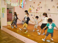 5歳児らいおん組が交代で舞台の上で盆踊りの見本を踊っている写真