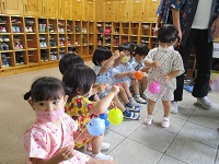 2歳児さんがヨーヨーをもって順番待ちをしている写真です。