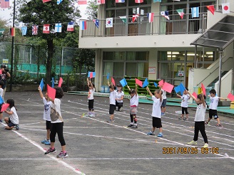 運動会で旗を振って踊る4歳児ぱんだ組の子どもたちの様子の写真