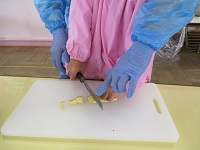 5歳児らいおん組が包丁で食材を切っている写真