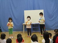 3歳児、4歳児、5歳児の園児が誕生カードを見せている写真です。