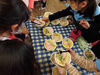 写真：お客さんのラーメンを渡しているところ