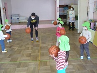 4歳児ぞう組がバスケットボーでドリブルの練習をしている写真
