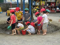 3歳児が泥んこ遊びをしている写真です。