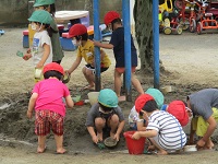 3歳児が泥んこ遊びをしている写真です。