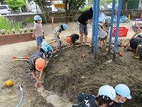 4歳児が川づくりをしている写真です。