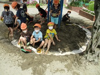 5歳児が足湯気分で泥水遊びをしている写真です。