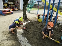 5歳児が泥んこ遊びをしている写真です。