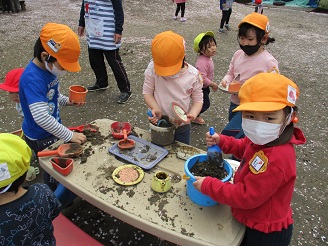 4歳児が砂場で遊んでいる様子の写真