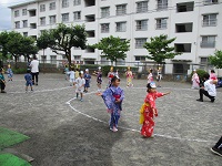 園庭で4歳児5歳児が盆踊りをしている写真です。