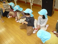 5歳児の子どもたちが、学童職員の説明を聞いている写真