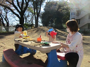 0歳児が園庭で遊んでいる様子の写真