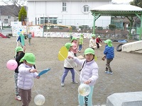 4歳児ぞう組が園庭風船羽根つきをしている写真