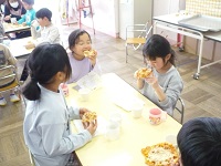 5歳児らいおん組ができあがったピザを食べている写真