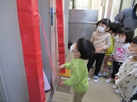 2歳児が保育園神社にお参りをしている写真です。