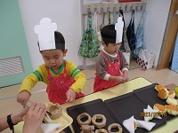 1歳児がパン屋さんごっこをしている写真です。