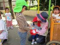 1歳児うさぎ組の子どもたちにペンダントを渡している写真