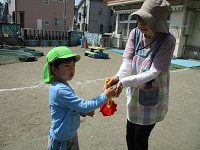 新しく来た職員にペンダントを渡している写真