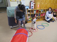 1歳児がフープで遊んでいる写真です。