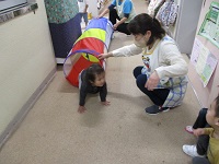 2歳児がトンネルで遊んでいる写真です。