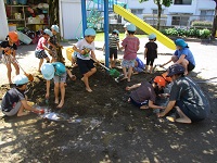 5歳児が泥んこ遊びをしている写真です。