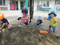 園庭で遊ぶ0歳児の写真1