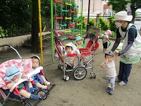 0歳児りす組の子どもたちが園庭で外気浴をしている写真