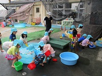 3歳児らいおん組の子どもたちが水遊びをしている写真