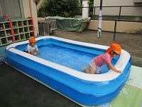 4歳児きりん組の子どもたちがビニールプールで泳いでいる写真