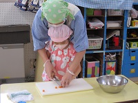 5歳児が調理活動でにんじんを切っている写真です。