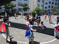 幼児クラスが園庭で盆踊りを踊っている写真です。