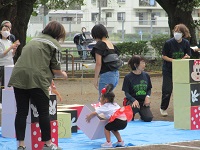 2歳児ぱんだ組の子どもが親子で積み木を倒している写真