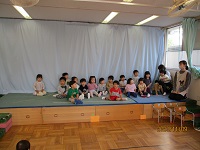 2歳児ぱんだ組の子どもが舞台で手遊びをしている写真
