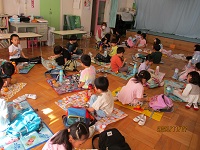 4歳児きりん組の子どもたちがホールでお弁当を食べている写真