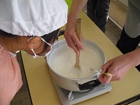 ミキサーにかけた大豆を、鍋で煮ているところを見ている写真