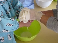 5歳児らいおん組が豆乳をしぼっている写真