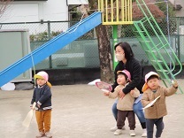 うちわで風船を打つ子どもの写真