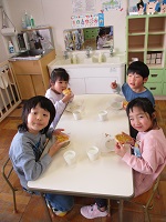 5歳児ぞう組の子どもたちができあがったピザを食べる写真